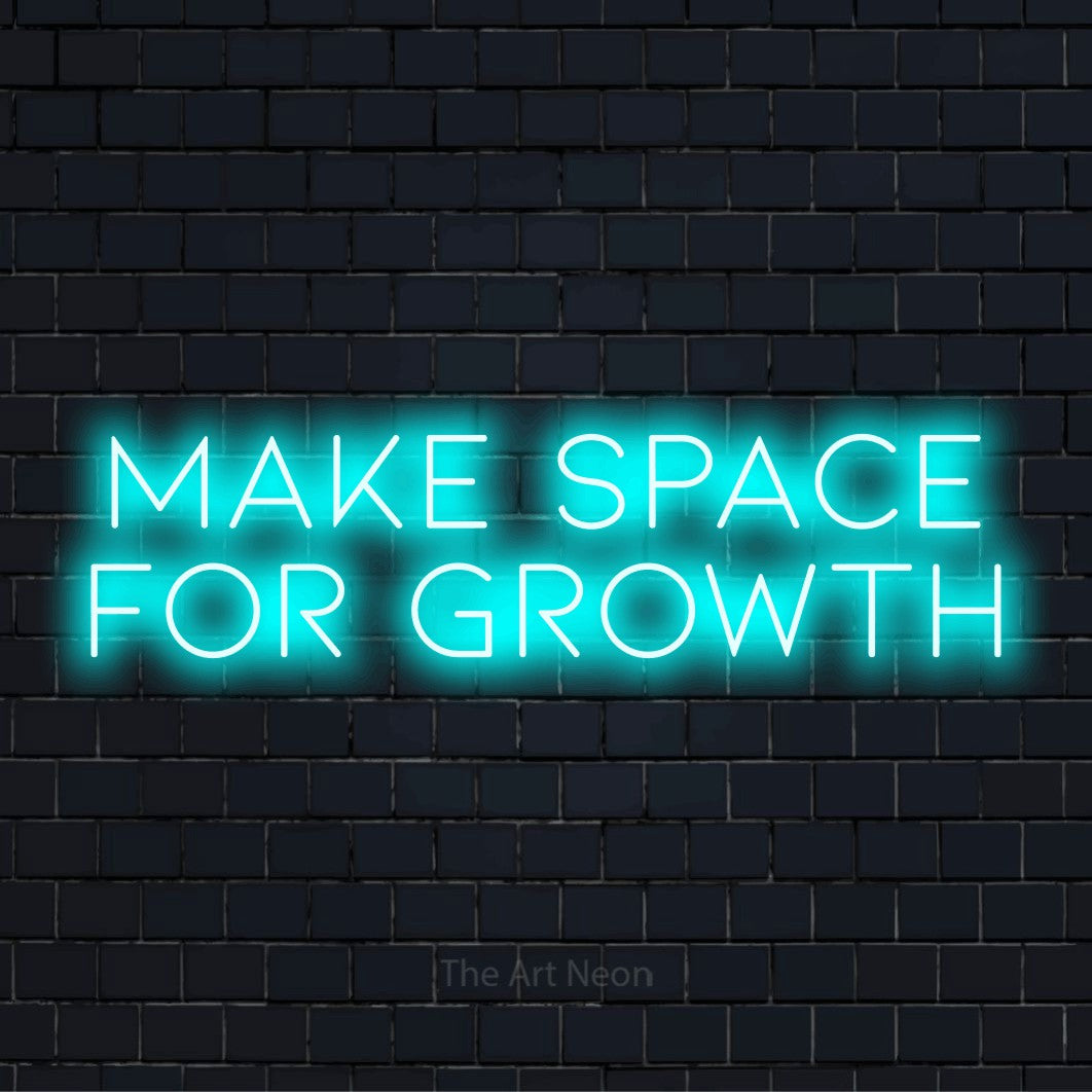 "Make Space For Growth" glowing LED neon sign on a black brick wall