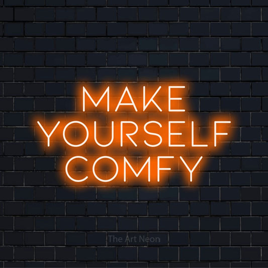 "Make Yourself Comfy" LED neon sign on a black brick wall