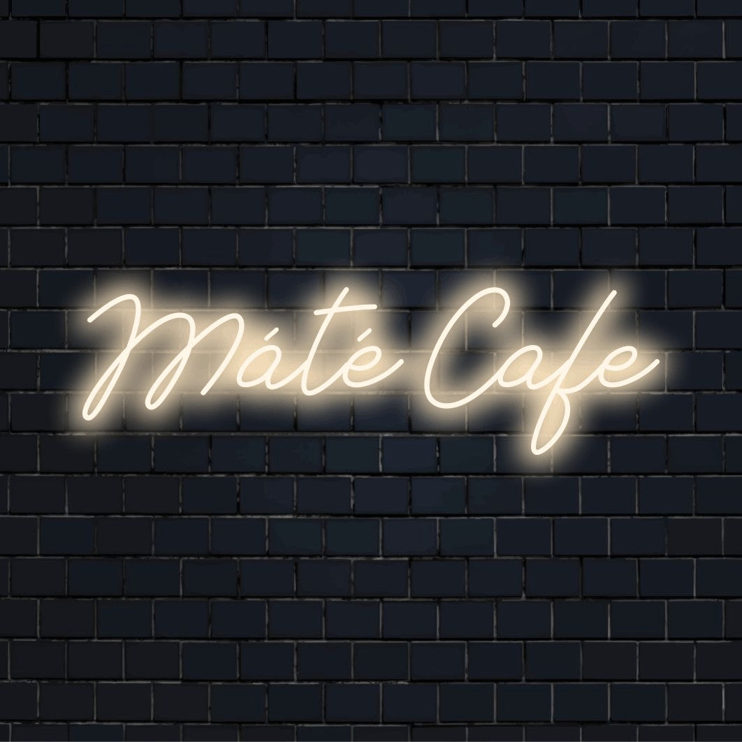 Mate Cafe Custom Name Neon Sign, glowing lettering on dark brick wall