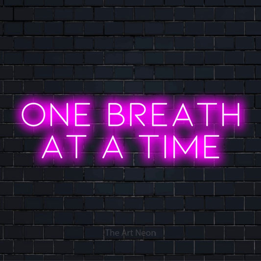 "One Breath At A Time" LED neon sign on a black brick wall