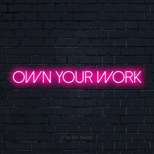 "Own Your Work" text design with neon effect on a black brick wall