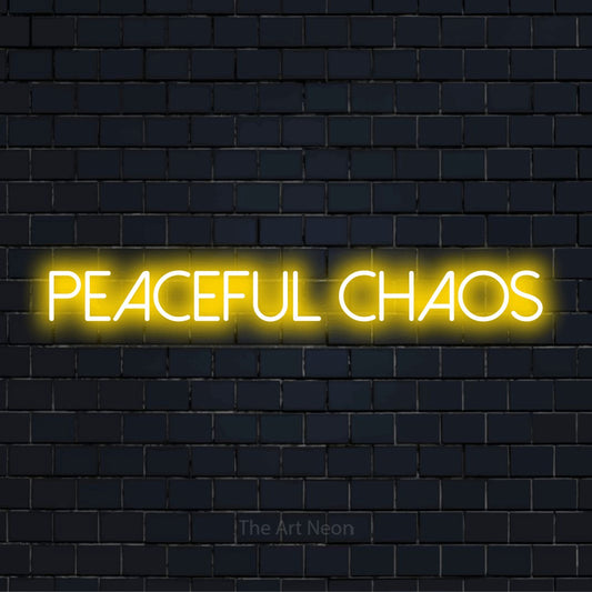 "Peaceful Chaos" text design with neon effect on a black brick wall