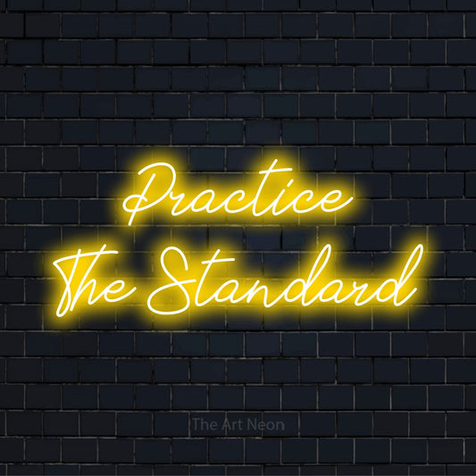 "Practice The Standard" glowing LED neon sign on a black brick wall