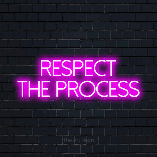 "Respect The Process" LED neon sign on a black brick wall