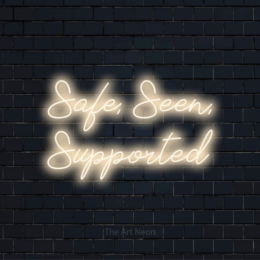 "Safe, Seen, Supported" text design with neon effect on a black brick wall