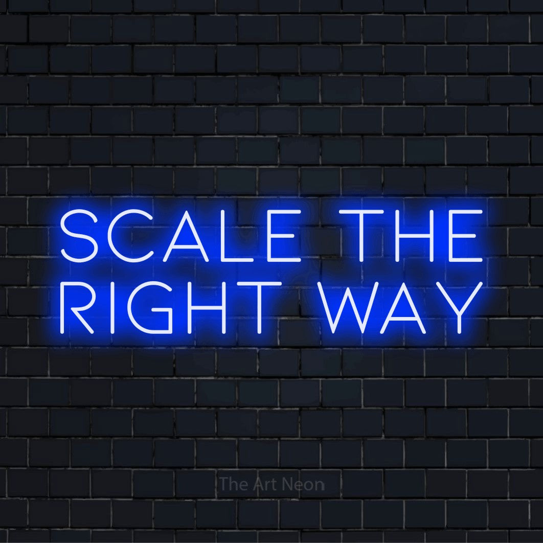 "Scale The Right Way" neon text design on a black brick wall