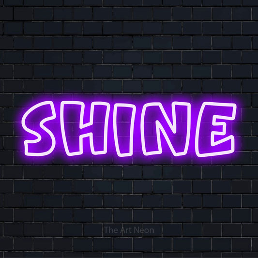 "Shine" script-style LED neon sign on a black brick wall