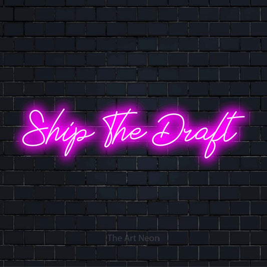 "Ship The Draft" glowing LED neon sign on a black brick wall