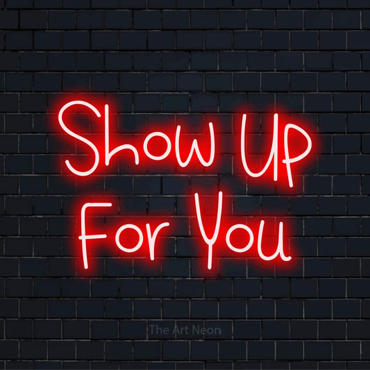 "Show Up For You" glowing LED neon sign on a black brick wall