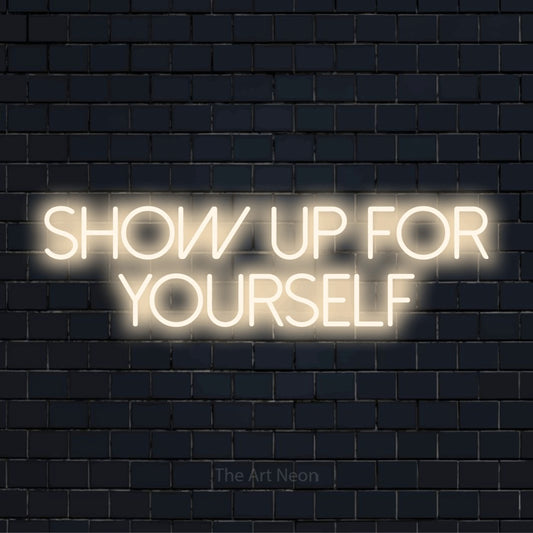 "Show Up For Yourself" text design with neon effect on a black brick wall