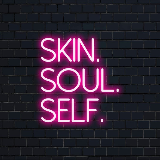 Skin Soul Self Neon Sign, bright LED glow on dark brick wall
