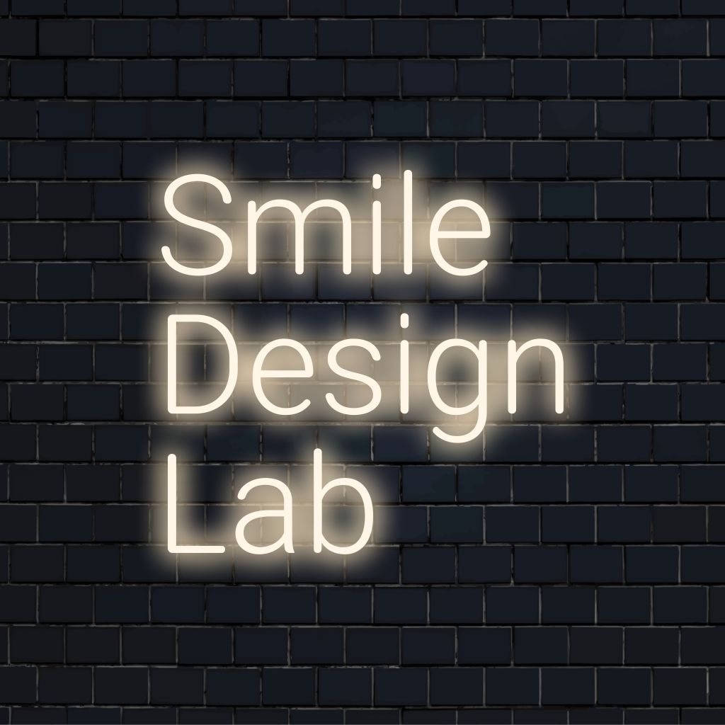 Smile Design Lab Neon Sign, glowing wall decor on dark brick wall