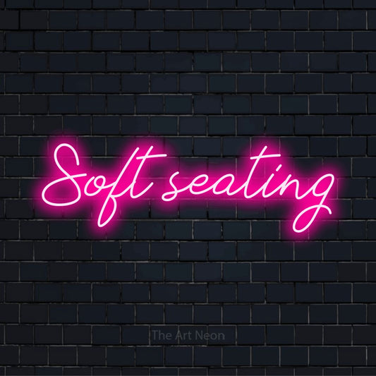"Soft Seating" text design with neon effect on a black brick wall