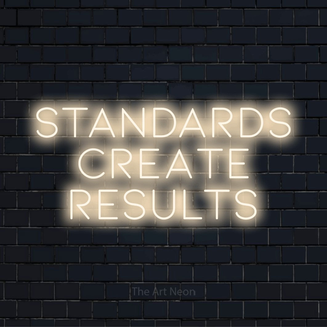 "Standards Create Results" LED neon sign on a black brick wall
