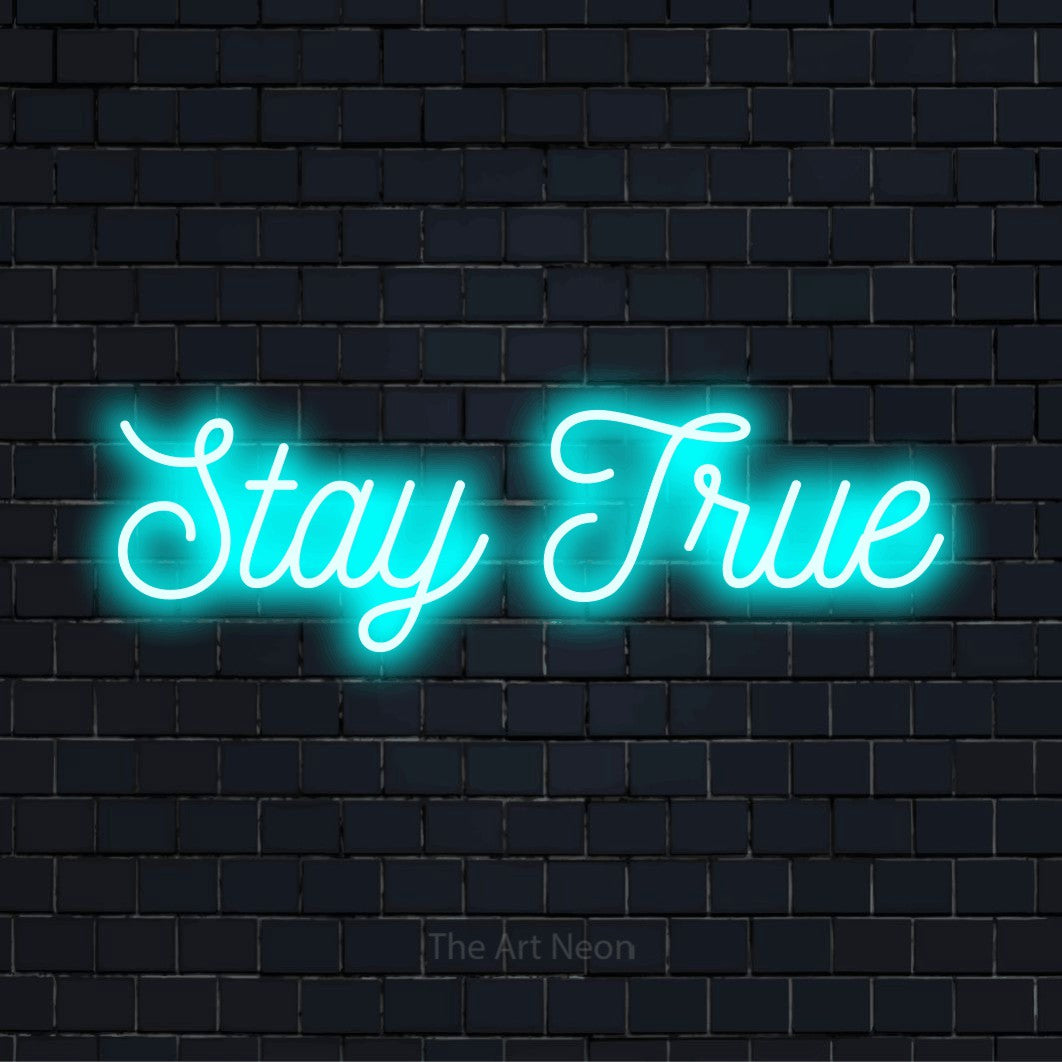 "Stay TRUE" script-style LED neon sign on a black brick wall
