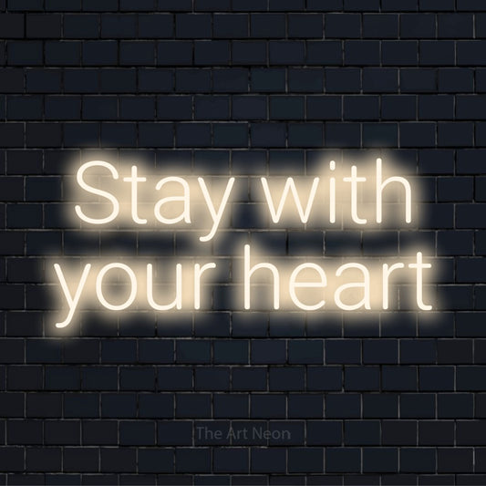 "Stay With Your Heart" text design with neon effect on a black brick wall