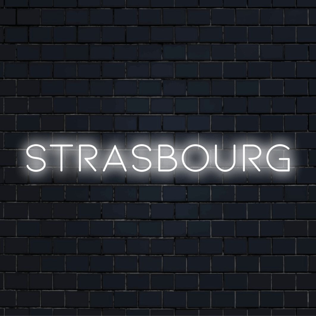 Strasbourg Neon Sign, soft neon glow against black brick wall