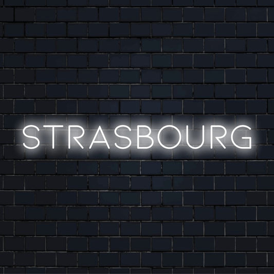 Strasbourg Neon Sign, soft neon glow against black brick wall