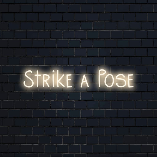 Strike A Pose Neon Sign, bright LED glow on dark brick background