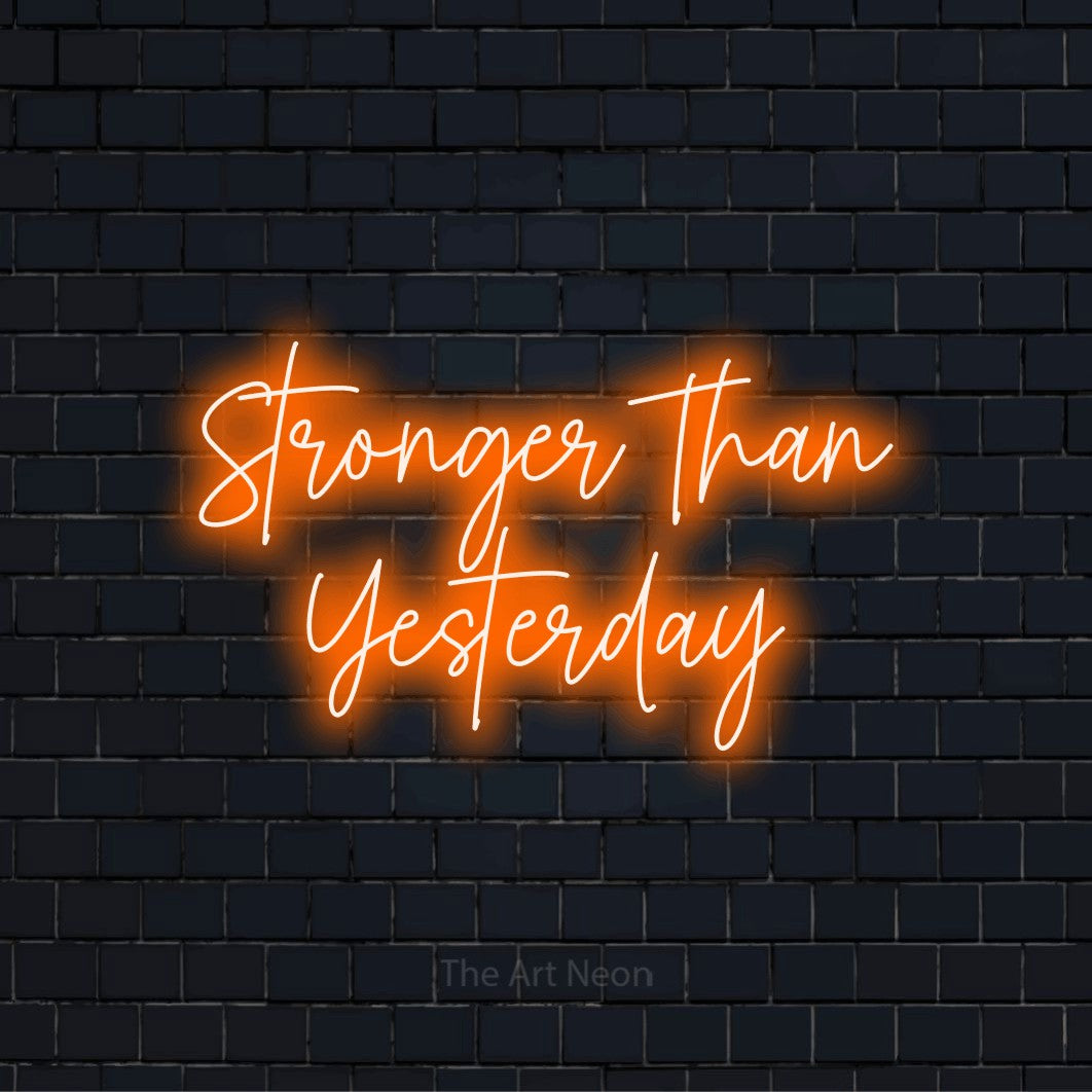 "Stronger Than Yesterday" LED neon sign on a black brick wall