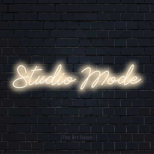 "Studio Mode" neon text design on a black brick wall