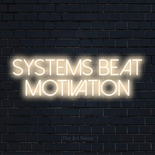 "Systems Beat Motivation" neon text design on a black brick wall