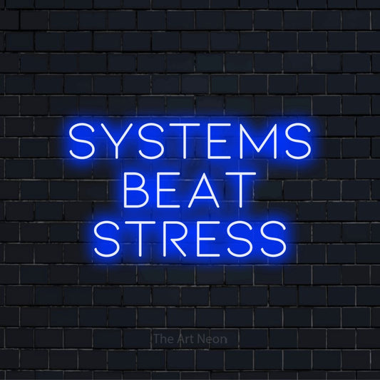 "Systems Beat Stress" LED neon sign on a black brick wall