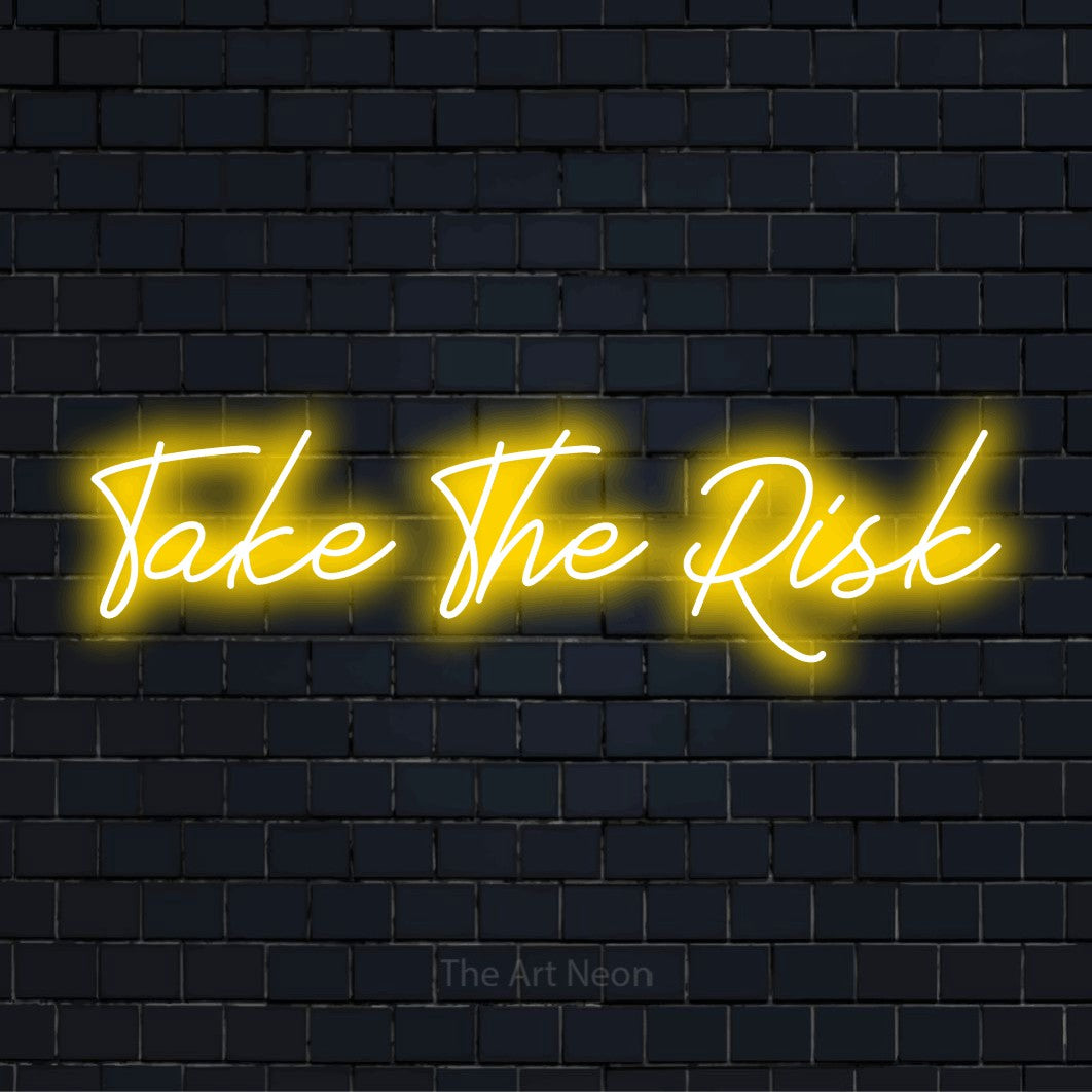 "Take The Risk" neon text design on a black brick wall