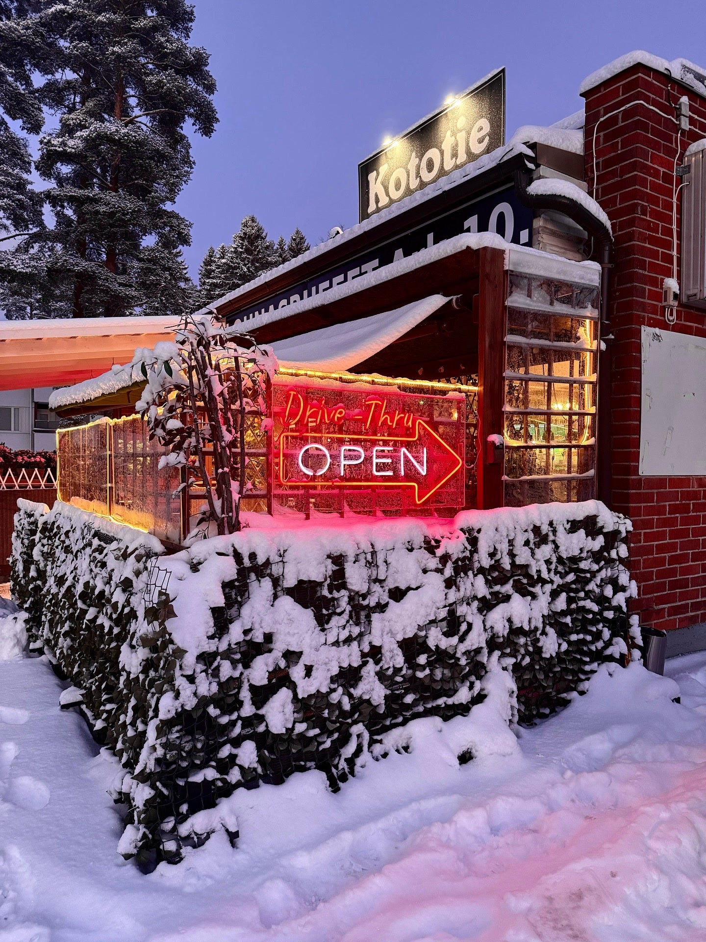 Red outdoor Drive-Thru OPEN LED neon sign at Kototie restaurant in snowy Seinäjoki