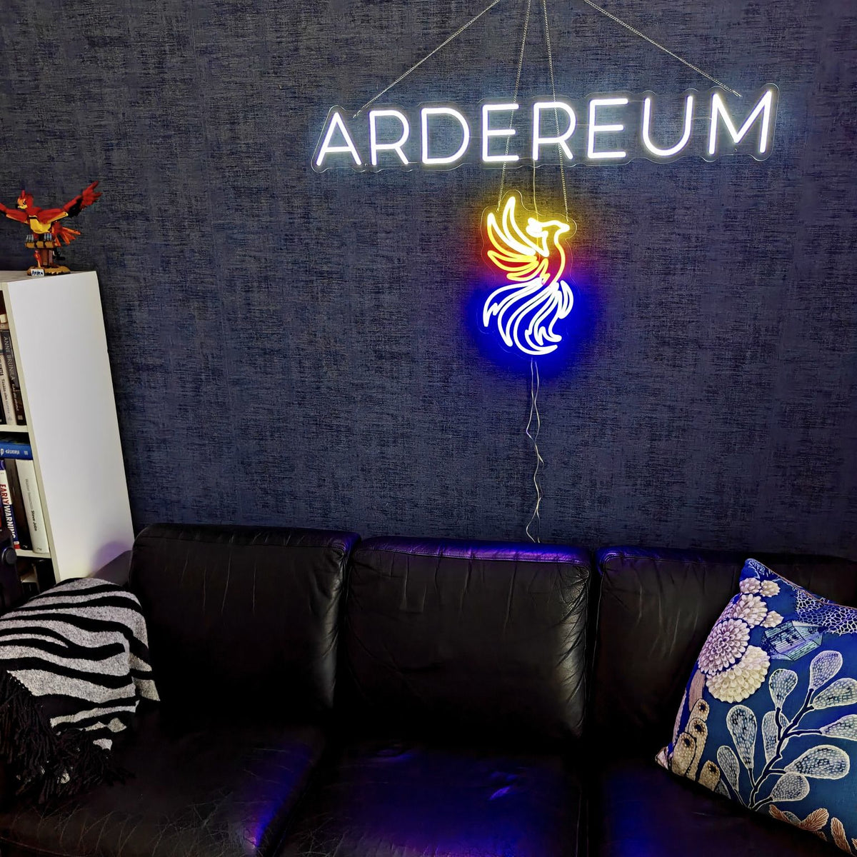 Valkoinen ARDEREUM-logon LED-neonvalokyltti tummalla, pintakuvioidulla toimistoseinällä.