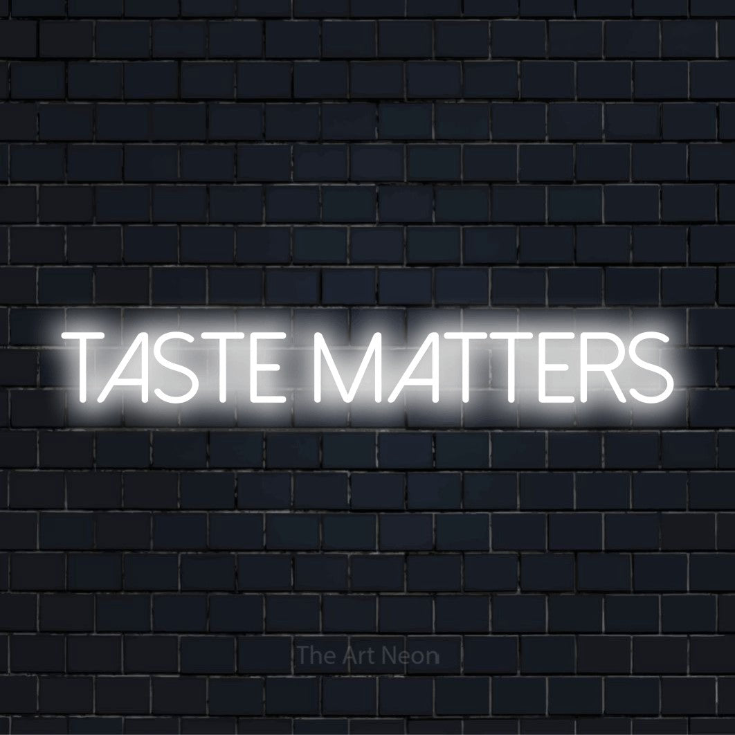 "Taste Matters" script-style LED neon sign on a black brick wall