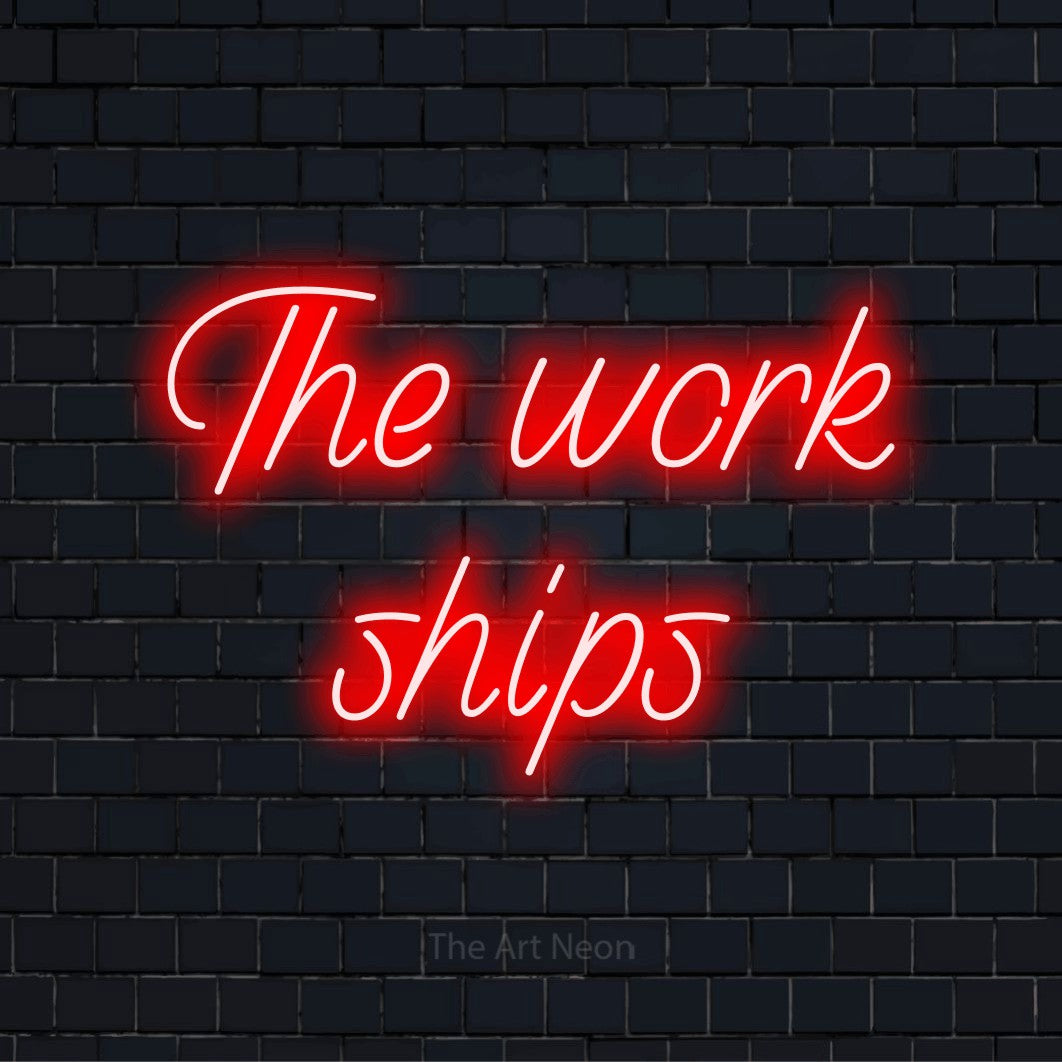 "The Work Ships" neon text design on a black brick wall