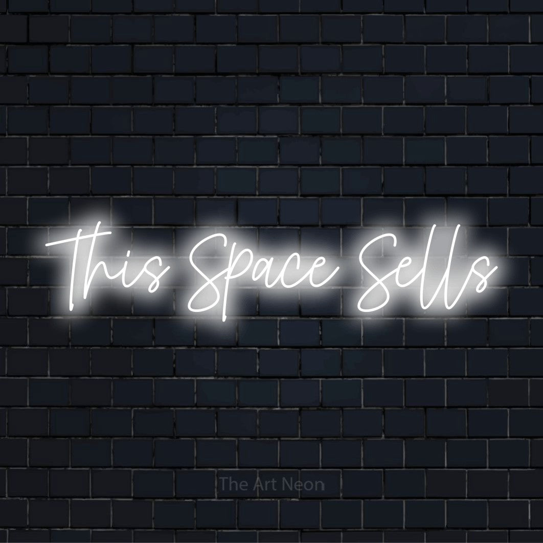 "This Space Sells" LED neon sign on a black brick wall