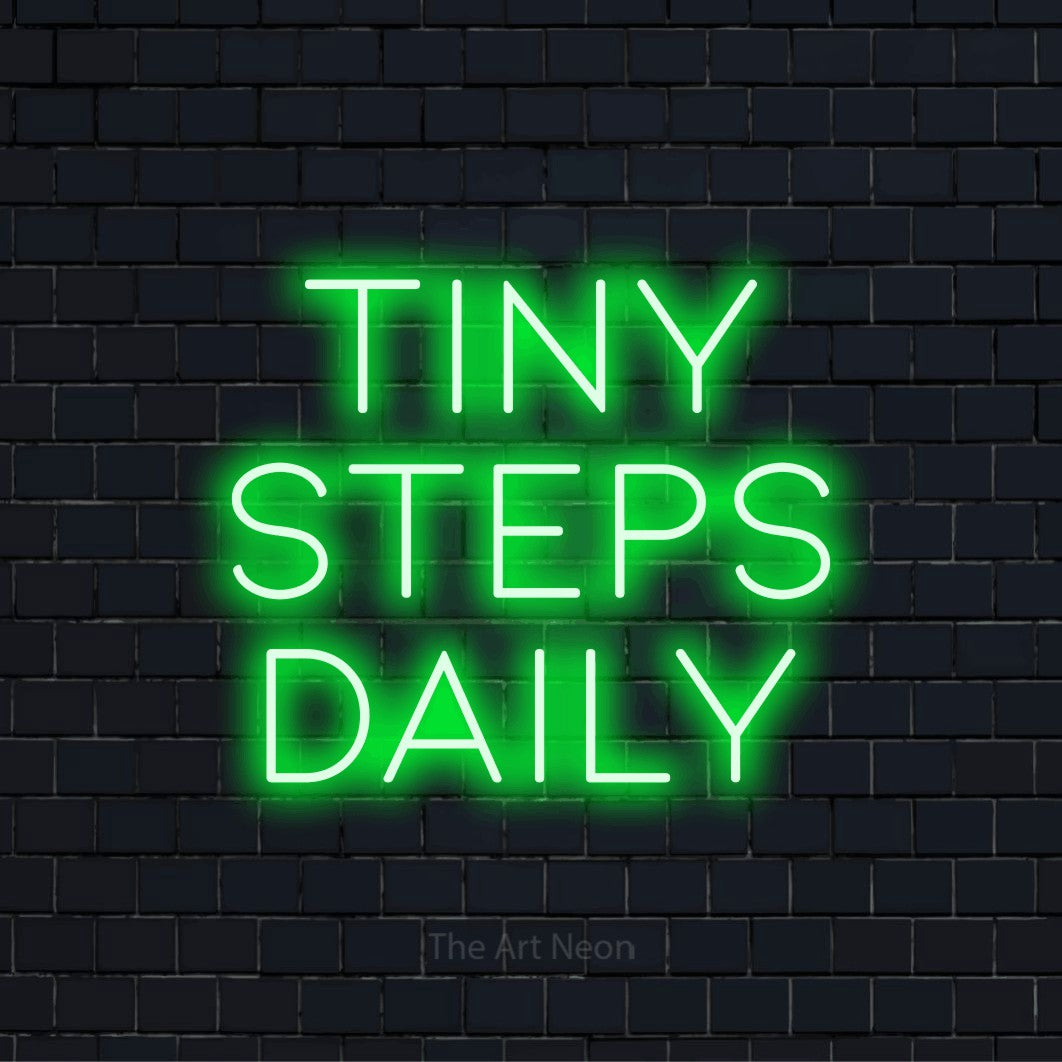 "Tiny Steps Daily" text design with neon effect on a black brick wall