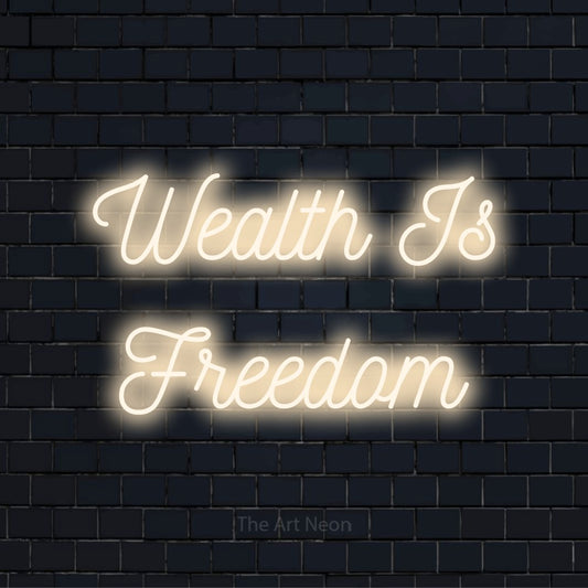 "Wealth Is Freedom" glowing LED neon sign on a black brick wall