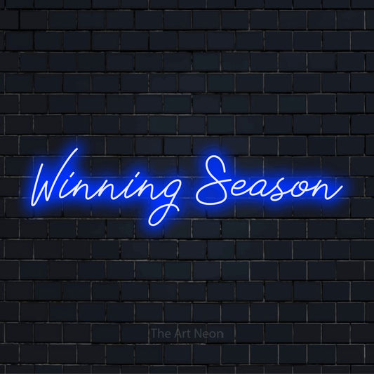 "Winning Season" script-style LED neon sign on a black brick wall