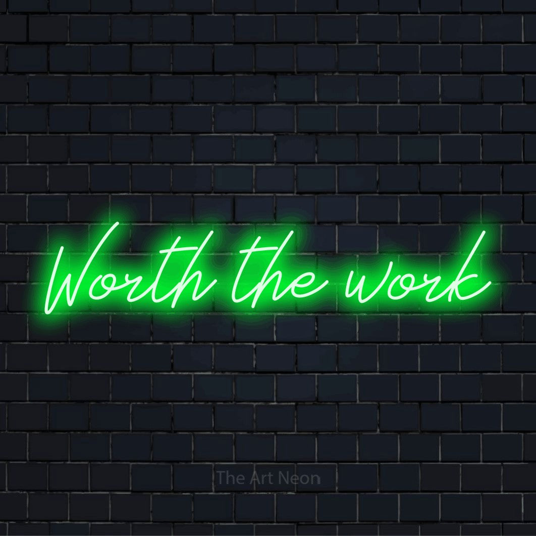 "Worth The Work" LED neon sign on a black brick wall