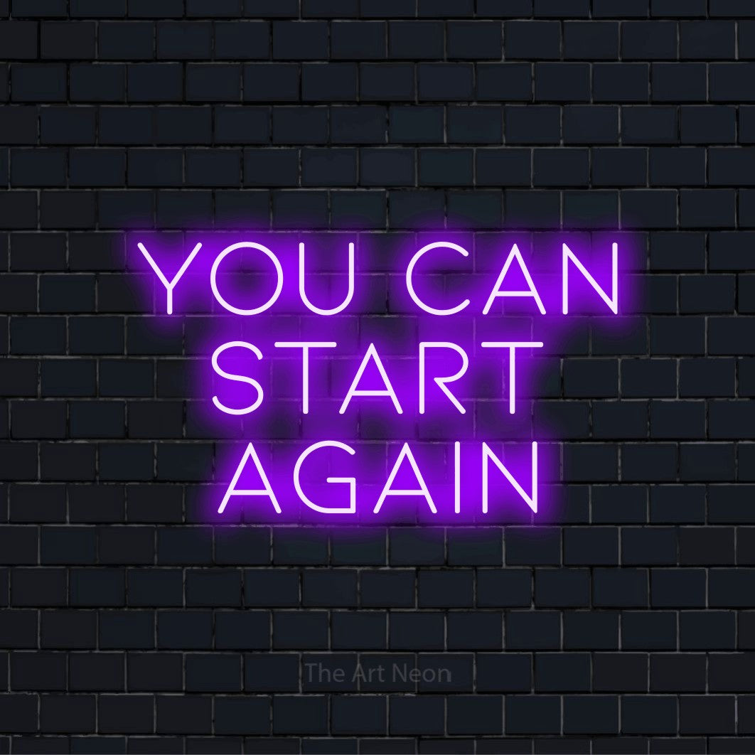 "You Can Start Again" text design with neon effect on a black brick wall