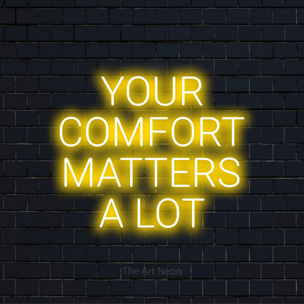 "Your Comfort Matters A Lot" glowing LED neon sign on a black brick wall