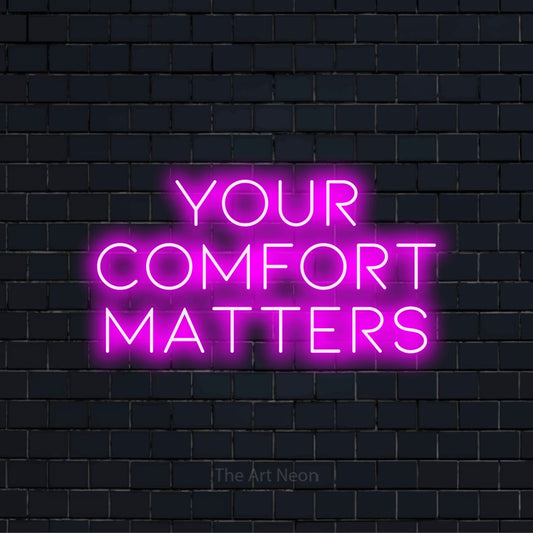 "Your Comfort Matters" script-style LED neon sign on a black brick wall