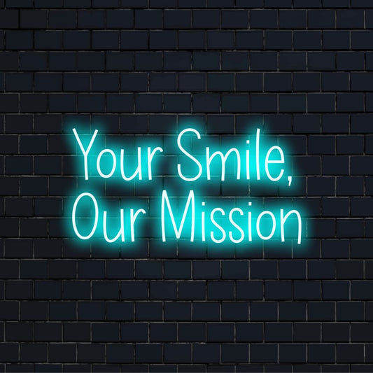 Your Smile Our Mission Neon Light with bright neon lettering against brick backdrop