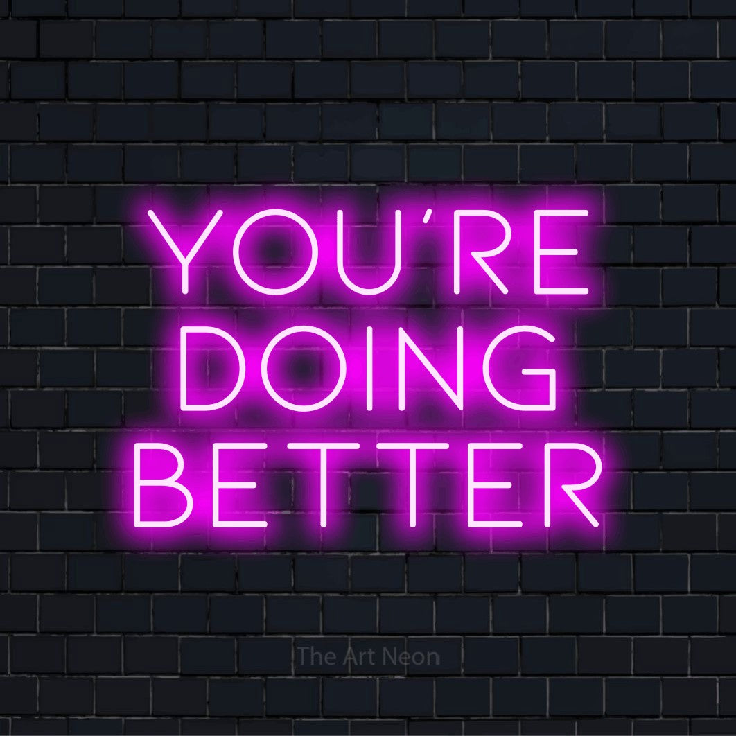 "You’re Doing Better" neon text design on a black brick wall
