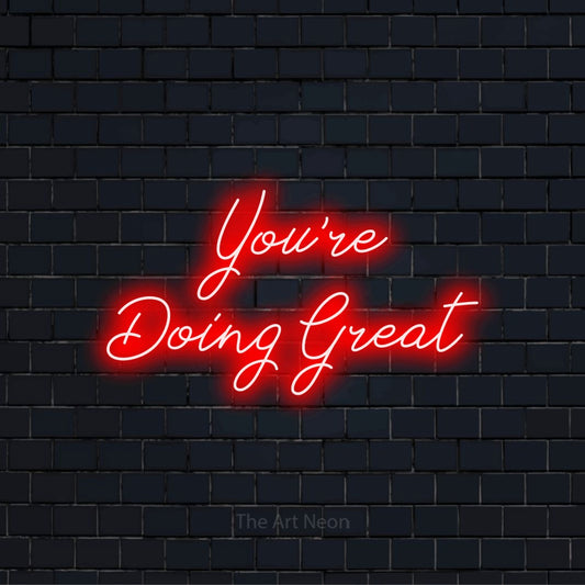 "You’re Doing Great" script-style LED neon sign on a black brick wall